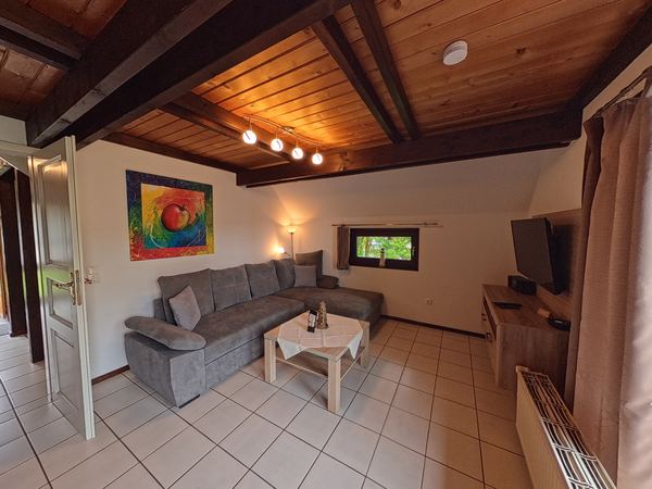 Wohnzimmer mit Fernseher und Sitzecke